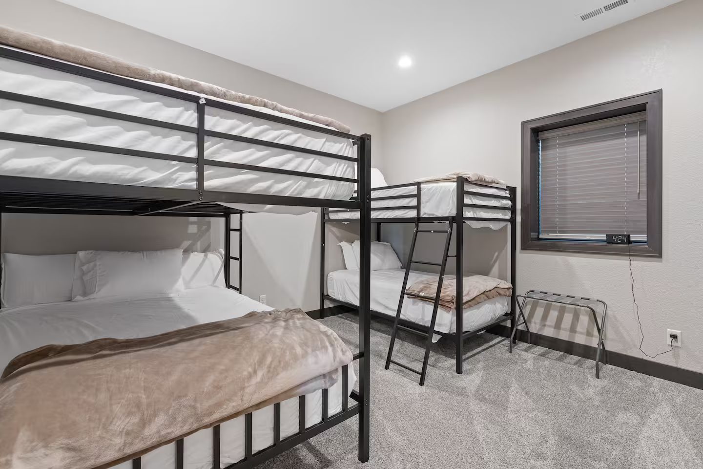 Bunk room with two black metal bunk sets and carpet