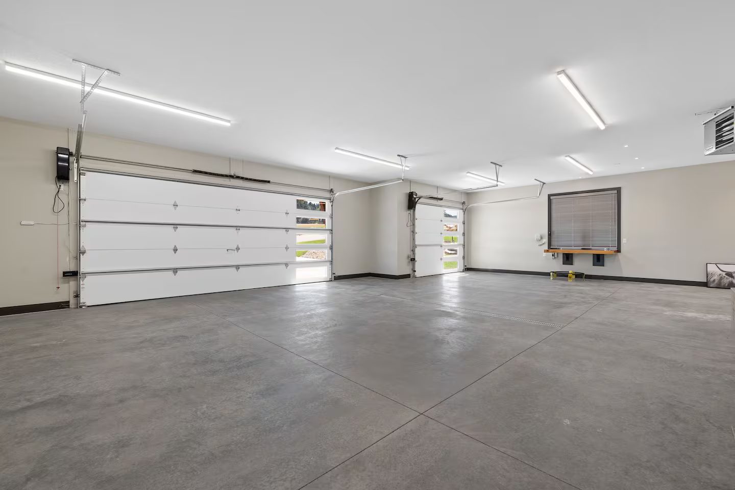Large garage at the Luxury Golf Course Retreat with a double and a single overhead door and smooth concrete floors, with room for motorcycles, side-by-sides and large vehicles